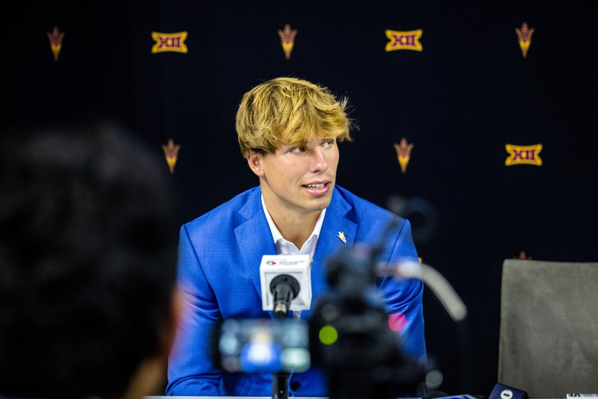 Young man in a blue suit sits for a media interview
